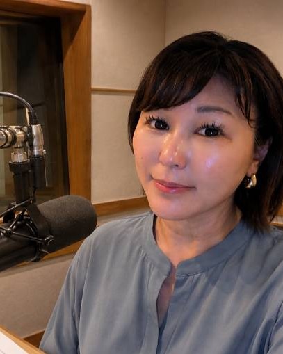 ラジオの収録ブースでマイクの前に座る佐伯桃子