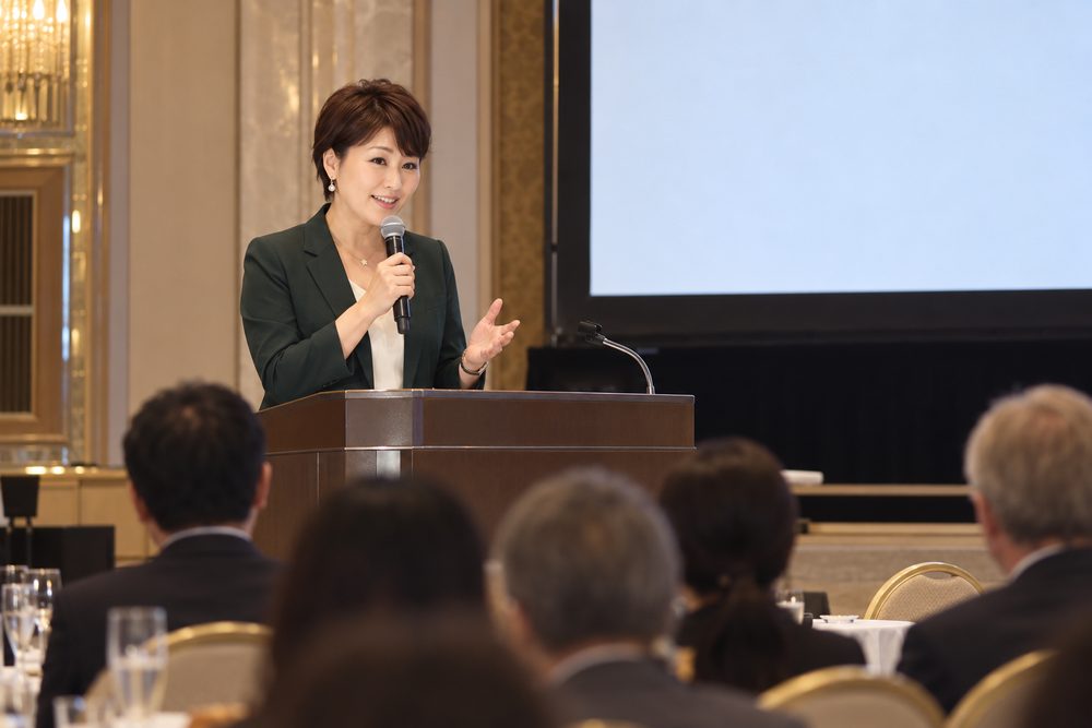 会場の演台でマイクを持って話す佐伯桃子